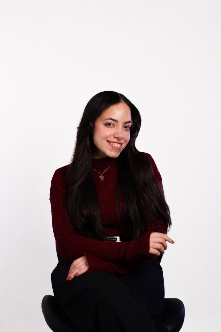 Professional portrait of a team member in a creative studio environment.